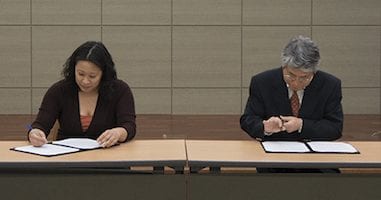 Two people signing documents