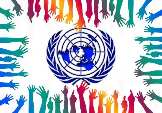 UN logo with multicolored hands reaching toward it