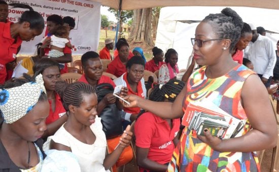 Members of the Center for Health, Human Rights and Development (CEHURD), a Ugandan NGO, distribute handbooks to adolescent girls and young women to guide them in enforcing the legal empowerment and social accountability strategy in pursuit of the right to health. 