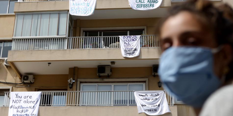 Apartment building with sheets hanging over the balconies, each displaying an anti-domestic violence message or hotline.