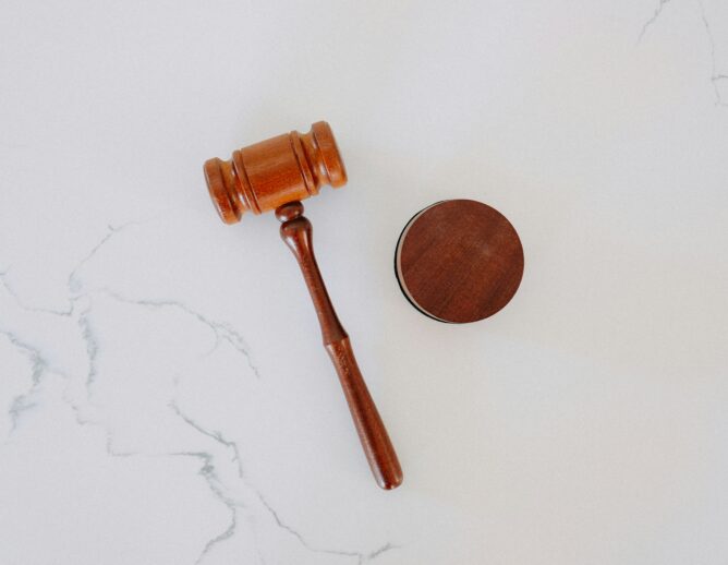 A wooden gavel on a white marble backdrop