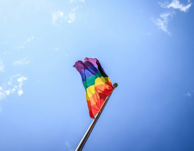 Rainbow flag against blue sky