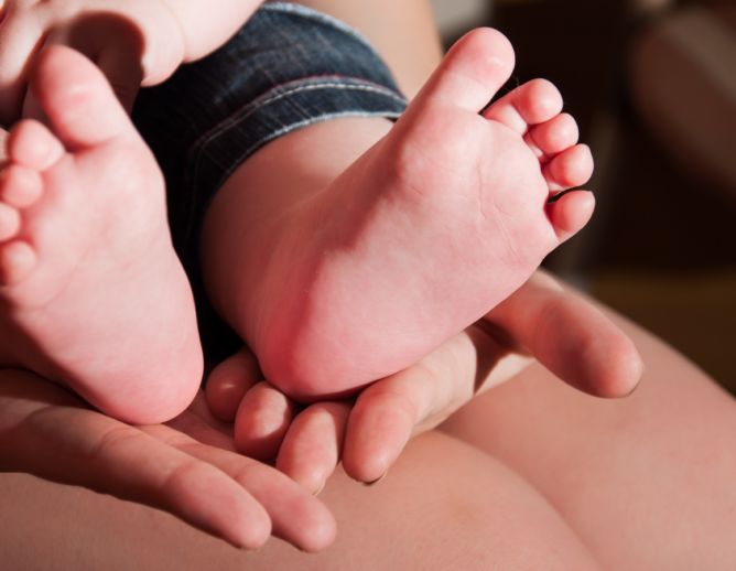 stock image of baby's feet being held in parent's hands